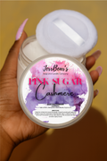 Jar of 'Pink Sugar Cashmere' candle held by a hand with a blurred background